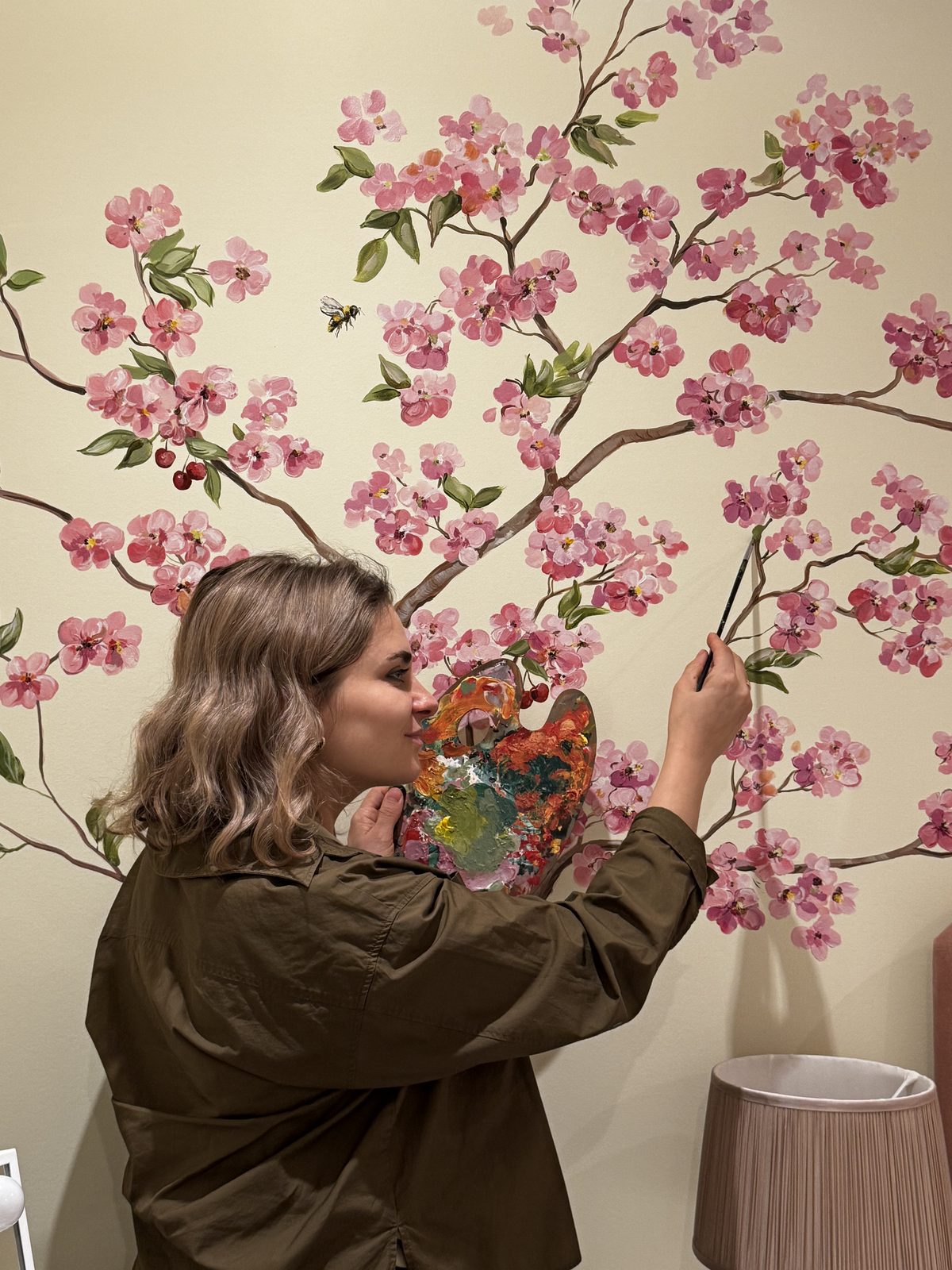 Bohdana painting a cherry blossom mural